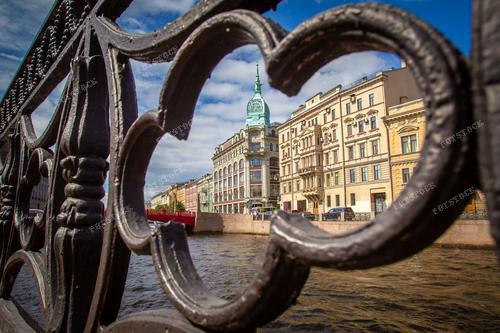 Это фото захватывает атмосферу летнего дня в самом центре Санкт-Петербурга. Река Мойка и набережная олицетворяют красоту и элегантность города. Яркое солнце освещает исторические фасады, создавая удивительный контраст с водной гладью. Этот кадр отражает уникальное сочетание природной красоты и культурного наследия России.
